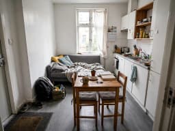 Kleine, vollgestellte Einzimmerwohnung mit Küche und Sofa, vor der Neugestaltung