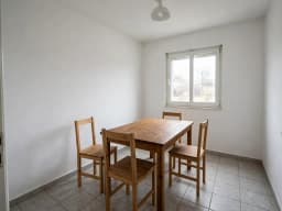 Plain dining room with a wooden table and four chairs, before decorating