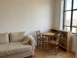 Small studio with a sofa bed, a round table and a bookcase, before decorating
