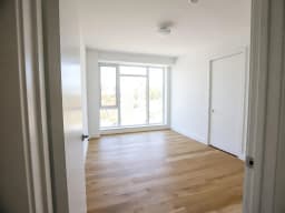 Leeres Schlafzimmer in einer Neubauwohnung mit großem Fenster, vor der Neugestaltung