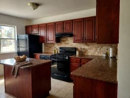 Dark cherry kitchen with brown granite and an island, before redesign