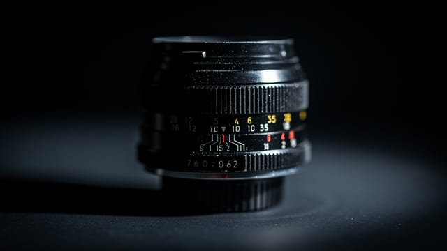 A vintage cinema lens on a dark surface